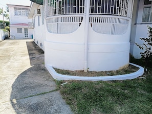 Una estructura cilíndrica con exterior blanco, posiblemente un depósito de agua, junto a un edificio con balcón.