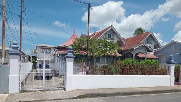 Un quartier résidentiel avec des maisons, une entrée sécurisée et un ciel dégagé.