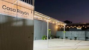 A building with a sign reading 'Casa Rayón' and a covered outdoor area with string lights.