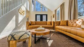 A living room with a sofa, a round coffee table, and a wooden bench.