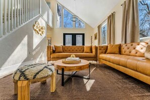 Ein Wohnzimmer mit einer Couch, einem runden Couchtisch und einer Holzbank.