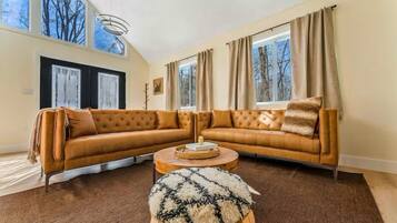 A living room with a large sectional sofa, a round coffee table, and a fluffy rug.