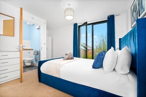 Ein Schlafzimmer mit Bett, Bad und Blick ins Freie.