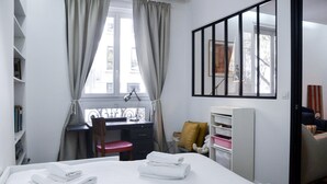 Une chambre à coucher comprenant un lit, un bureau, une chaise et une armoire.