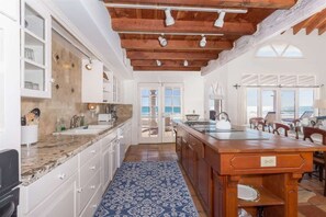 A spacious kitchen with a large island, white cabinetry, and a blue patterned rug. - Stunning, Cozy Beachfront Home Paz de Penasco (Puerto Peñasco)