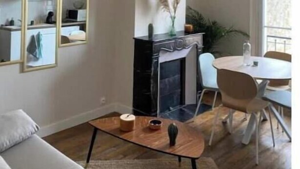 Un salon moderne avec une cheminée, un coin repas et une grande fenêtre.