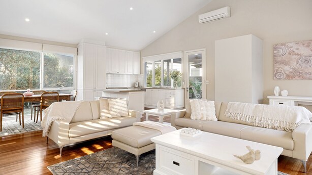A modern living room with a sofa, coffee table, and dining area.