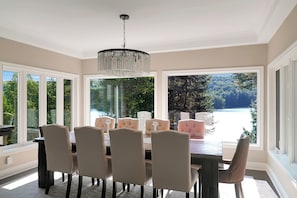 Comedor con candelabro, ventanas amplias y vistas al exterior.