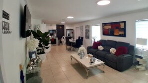 A modern living room with a sofa, coffee table, and decorative items. - Cozy vacation home w/ a spacious outdoor area. Near to great beaches and casinos (Hollywood)