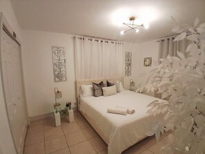 A bedroom with a bed, curtains, a ceiling light fixture, and wall art. - Cozy vacation home w/ a spacious outdoor area. Near to great beaches and casinos (Hollywood)