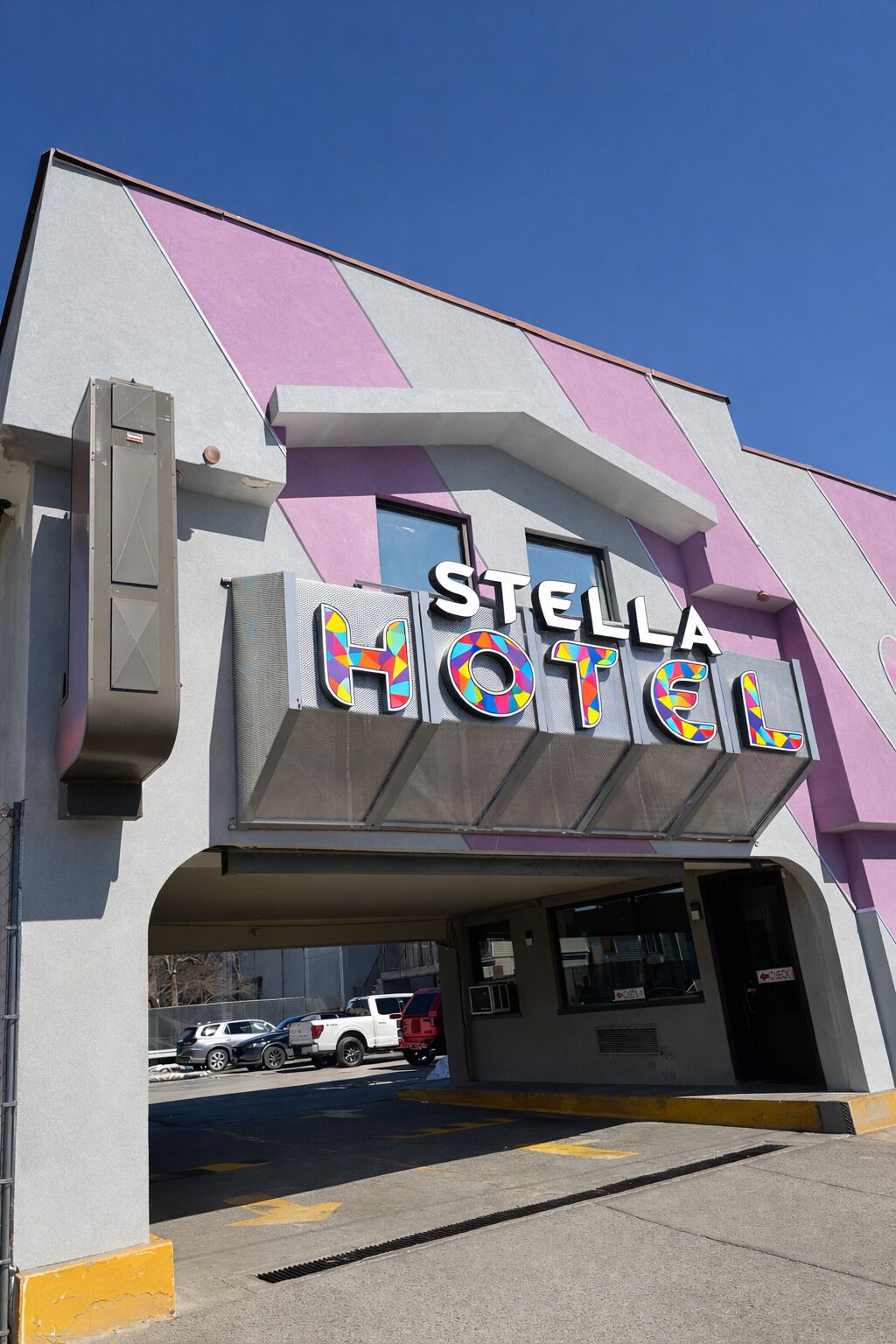 A hotel with a modern design, featuring a prominent sign that reads 'STELLA HOTEL' in bold letters.