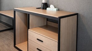 A hotel room with a flat-screen TV mounted on the wall, a wooden desk with drawers, a coffee maker, and a tissue box. - Stella Hotel Bronx (Bronx)
