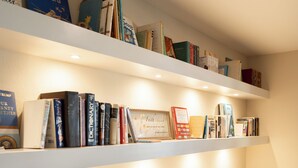 A kitchen with white cabinetry, a countertop, and a shelf with books. - Charming 2-Bedroom Townhome Attached Garage Near Downtown Georgetown (Georgetown)