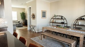 A dining area with a wooden table, chairs, a bench, and a rug. - Charming 2-Bedroom Townhome Attached Garage Near Downtown Georgetown (Georgetown)