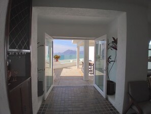 A hallway leading to a balcony with a view of the sea and mountains, potted plants, and a tiled floor. - Manzanillo Private Plunge Pool Ocean Views (Manzanillo)