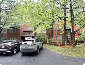 A residential driveway with two parked cars and a house with a red roof. - Sasquatch Sanctuary: Luxe, Cozy, Wilderness Vibes (Lake Harmony)