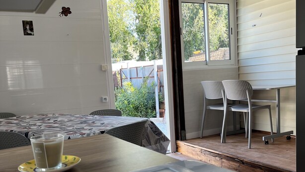 Een kamer met een bed, een tafel met een kopje en een stoel.