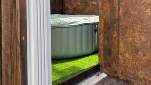 Een kamer met een houten wand, een raam en een matras.