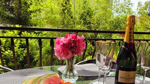 Una mesa con una botella de Moët & Chandon, una tajada de sandía y un jarrón con flores rosas.