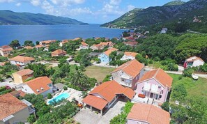 Un village côtier avec des maisons, une piscine et une vue sur la mer.
