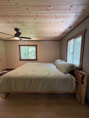 A bedroom with a bed, a ceiling fan, a window, and a nightstand. - Ski-In ⛷ & Golf with Million-Dollar Mountain Views, Quick Drive to Asheville (Mars Hill)