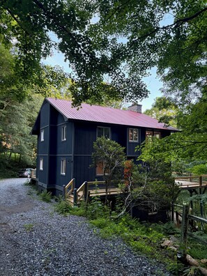 A dark blue cabin with a red roof, surrounded by trees and a gravel path. - Ski-In ⛷ & Golf with Million-Dollar Mountain Views, Quick Drive to Asheville (Mars Hill)