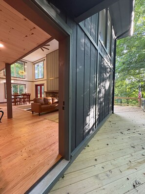 An interior space with a wooden floor, a sofa, and a dining area. - Ski-In ⛷ & Golf with Million-Dollar Mountain Views, Quick Drive to Asheville (Mars Hill)