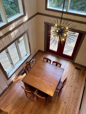 A dining area with a wooden table and chairs, large windows, and a decorative light fixture. - Ski-In ⛷ & Golf with Million-Dollar Mountain Views, Quick Drive to Asheville (Mars Hill)