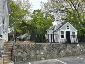 A stone wall with numbered sections, a gated area, and a small house with a black door.
