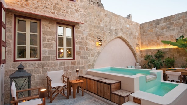 A stone building with a hot tub, wooden furniture, and a lantern. - Vivila in the Medieval City of Rhodes (Rhodes)