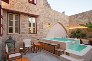 A stone building with a hot tub, wooden furniture, and a lantern. - Vivila in the Medieval City of Rhodes (Rhodes)