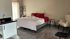 Une chambre d’hôtel avec un lit, un bureau, une chaise et une petite table.