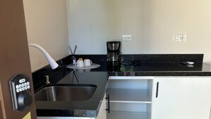 Une cuisine équipée d’un évier, d’une machine à café et d’une porte portant le numéro 2.
