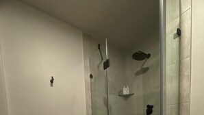 Une salle de bain avec une baignoire, une douche à parois de verre et des toilettes.