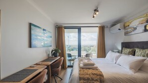 Una camera d'albergo con un letto, una scrivania, una sedia e vista dalla finestra.