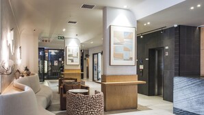 Una hall moderna con reception, area relax e una scalinata.