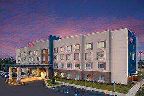 Un hôtel moderne à la façade sobre, doté de nombreuses fenêtres et offrant une vue sur un ciel dégagé.