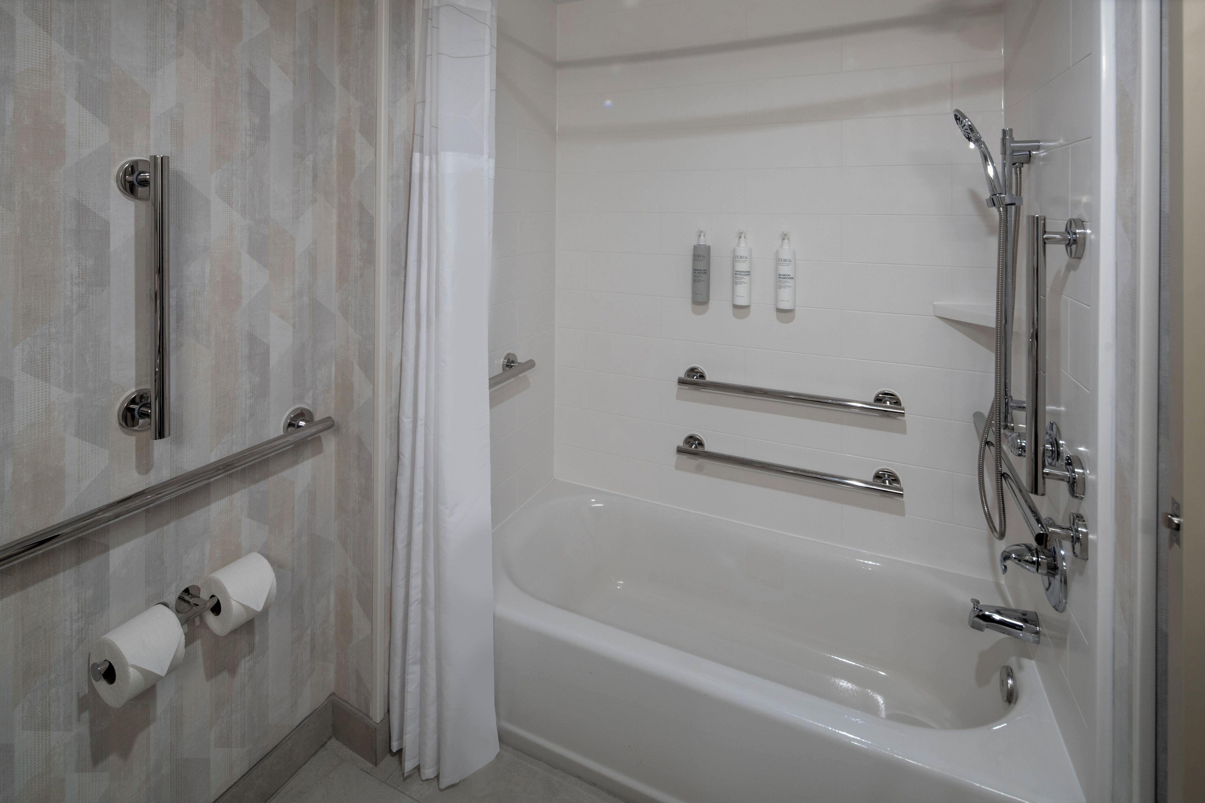 Un baño moderno con bañera, ducha e inodoro.