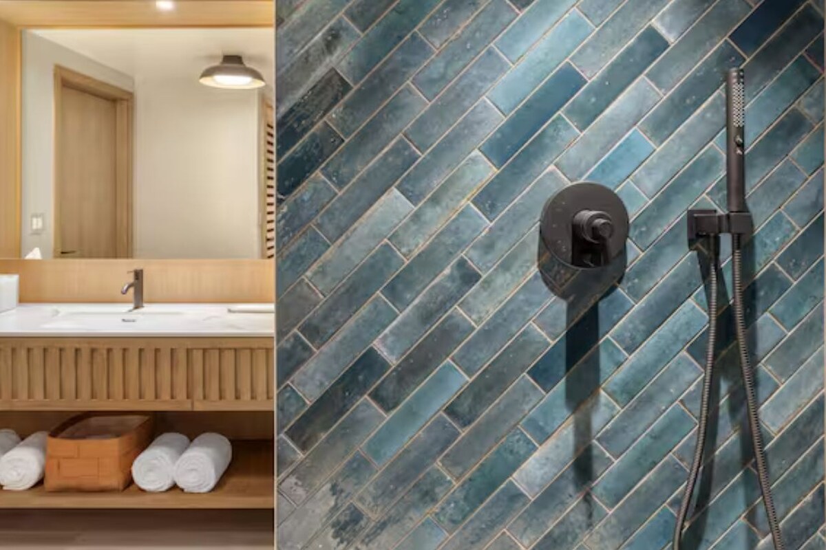 A bathroom with a herringbone tile backsplash, a sink with a wooden vanity, and a towel rack with rolled towels.