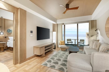 A hotel room with a large bed, wooden paneling, a city view, a round table, and a large mirror. at Hilton Club Ka Haku Honolulu