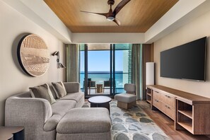 A modern living room with a large window, a ceiling fan, and a flat-screen TV. - Hilton Club Ka Haku Honolulu (Honolulu)