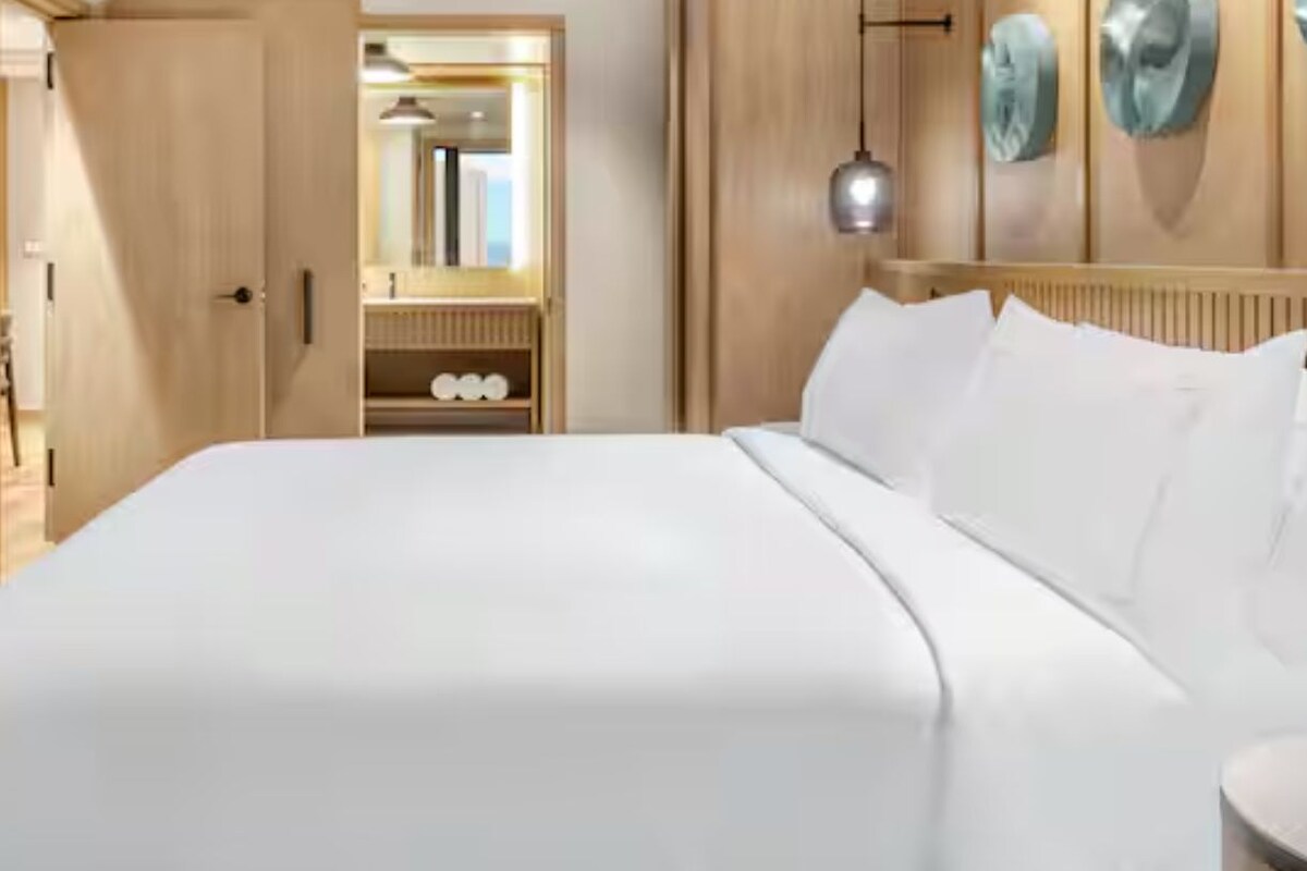 Een hotelkamer met een bed, een kledingkast en een spiegel.