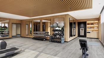 A lobby with a wooden wall, two elevators, a potted plant, and a modern chandelier. at Hilton Club Ka Haku Honolulu