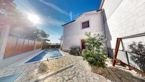 A swimming pool with stone tiles, a covered object, and a potted plant. - Villa in Kavac with beautiful sea view (Kavač)