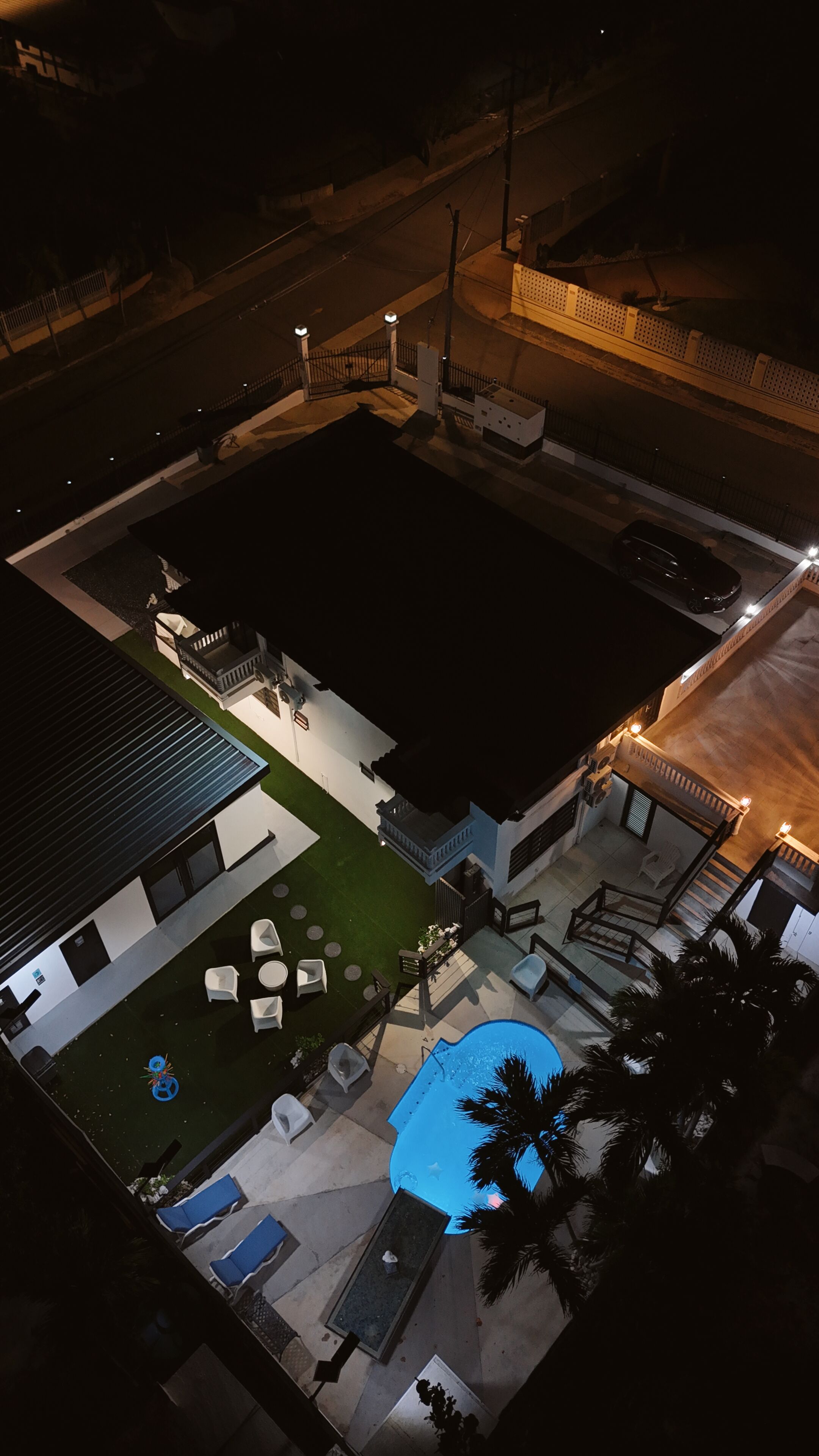 Ein Wohnhaus mit Pool, Sitzgelegenheiten im Freien und einer überdachten Terrasse.