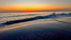 Uma praia com ondas ao pôr do sol.