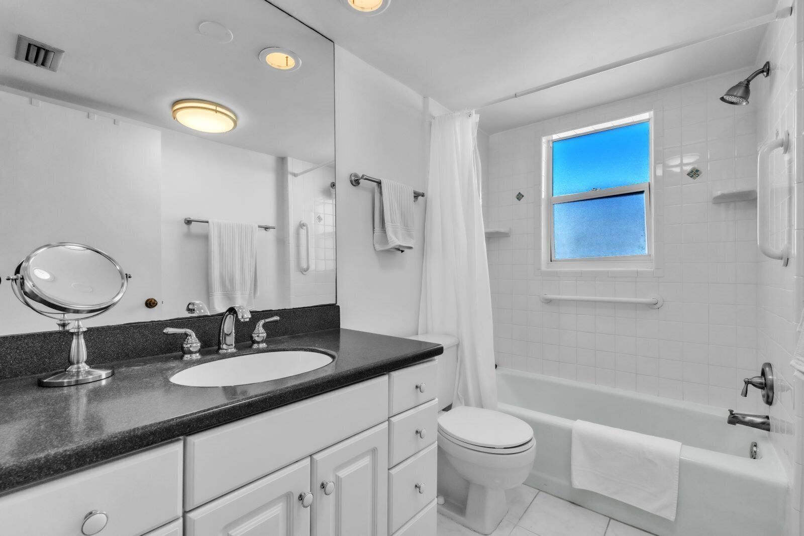 Un baño moderno con lavamanos doble, inodoro, bañera y ducha.