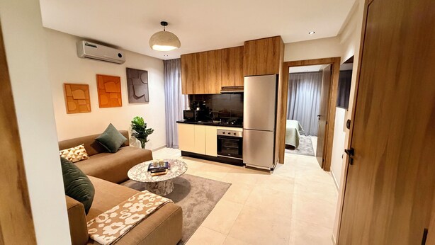A modern apartment with a living room, kitchen, and a dining area. - Élégance Moderne à Gueliz 1 Bedroom and Living Room (Marrakech)