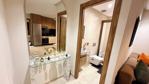 A modern interior with a kitchen, bathroom, and living area. - Élégance Moderne à Gueliz 1 Bedroom and Living Room (Marrakech)