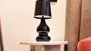 A black table lamp on a white marble pedestal in a room. - Élégance Moderne à Gueliz 1 Bedroom and Living Room (Marrakech)